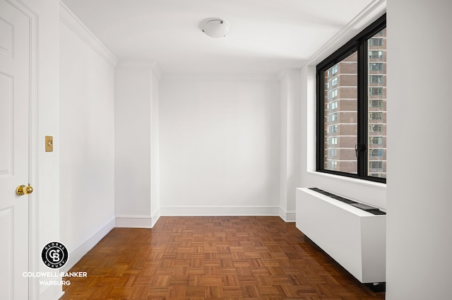 corridor featuring radiator heating unit, baseboards, and crown molding