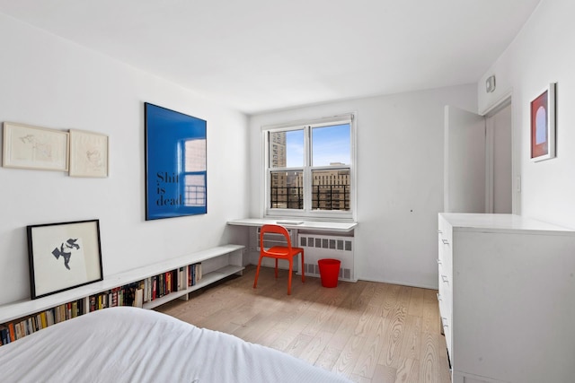 bedroom with light wood-style floors and radiator