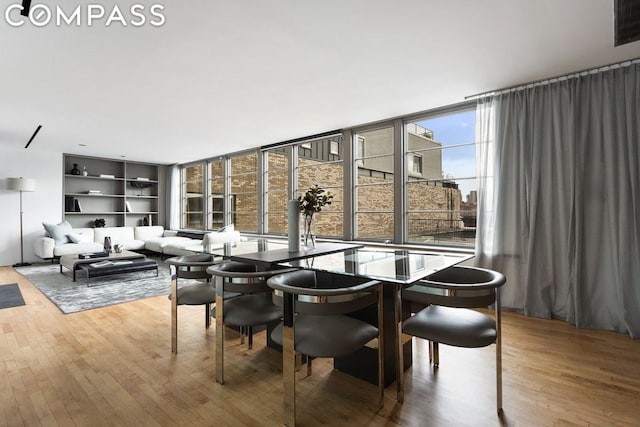 dining space featuring hardwood / wood-style flooring and expansive windows