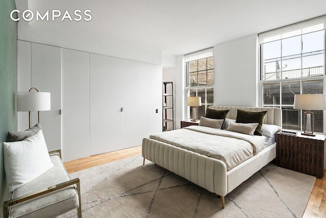 bedroom featuring a wall of windows and light wood-type flooring