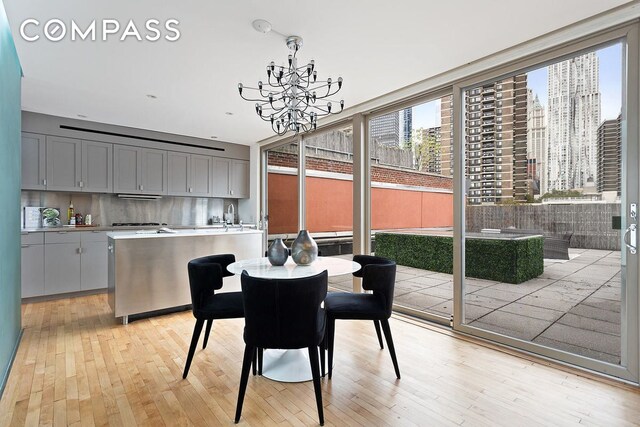 dining space featuring an inviting chandelier, light hardwood / wood-style floors, and floor to ceiling windows