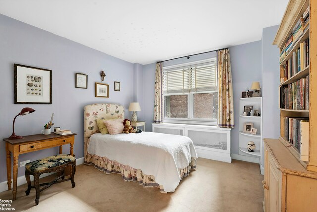 bedroom with light colored carpet and radiator heating unit