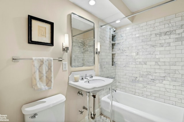 bathroom with tiled shower / bath combo and toilet