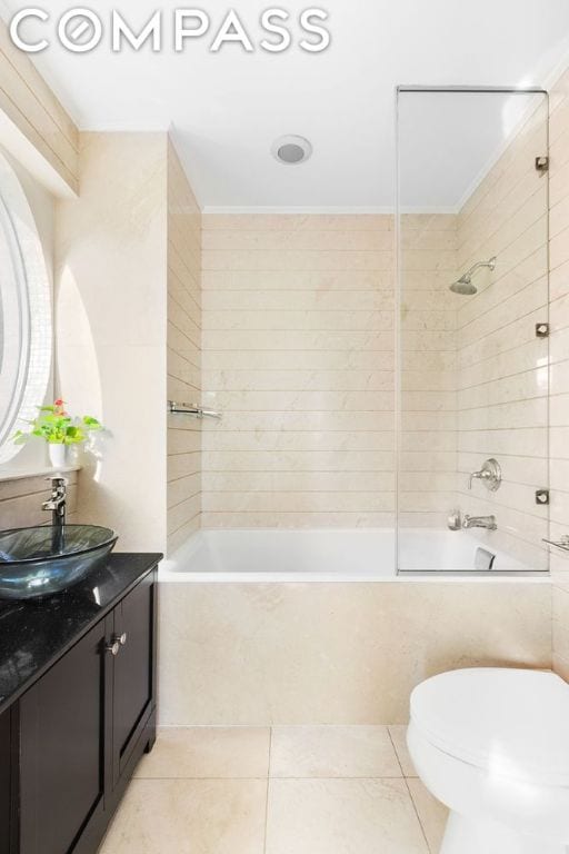 full bathroom featuring toilet, tile patterned flooring, tiled shower / bath, and vanity