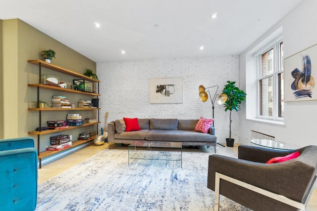 living room with brick wall and light wood-type flooring