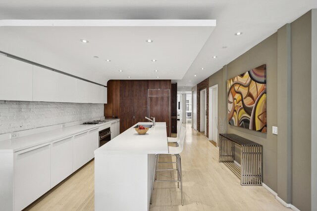 dining area featuring brick wall, light hardwood / wood-style floors, and radiator heating unit