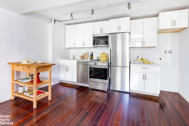 kitchen featuring white cabinetry, track lighting, stainless steel appliances, and dark wood-type flooring