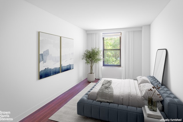 bedroom with baseboards and wood finished floors