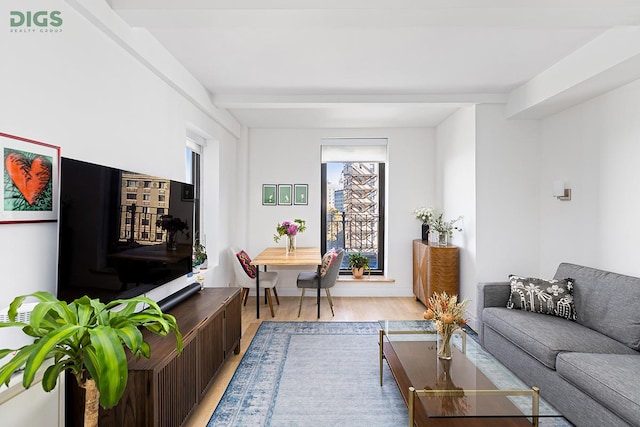 living area featuring light wood-style floors and beamed ceiling