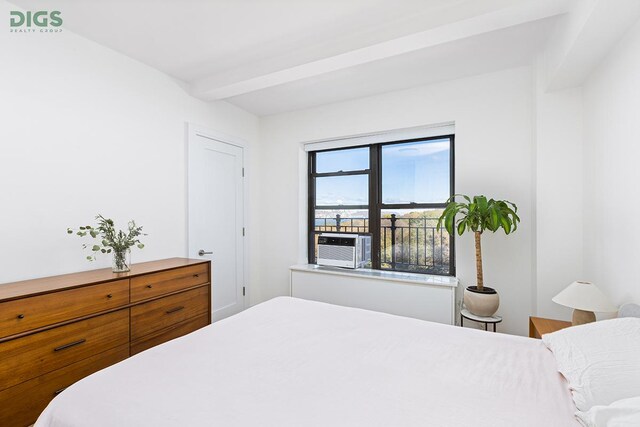 bedroom with beamed ceiling and cooling unit