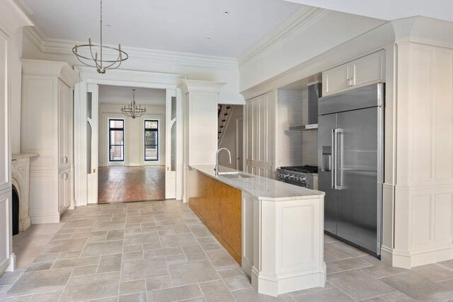 kitchen with stainless steel refrigerator with ice dispenser, wall chimney exhaust hood, a kitchen island with sink, decorative backsplash, and stove