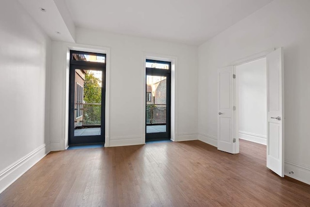 empty room featuring baseboards and wood finished floors