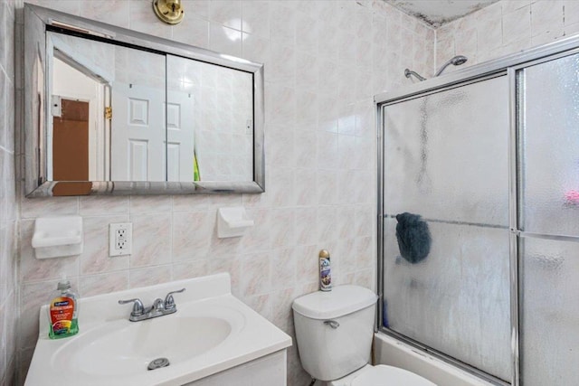 full bathroom featuring toilet, tile walls, decorative backsplash, shower / bath combination with glass door, and vanity