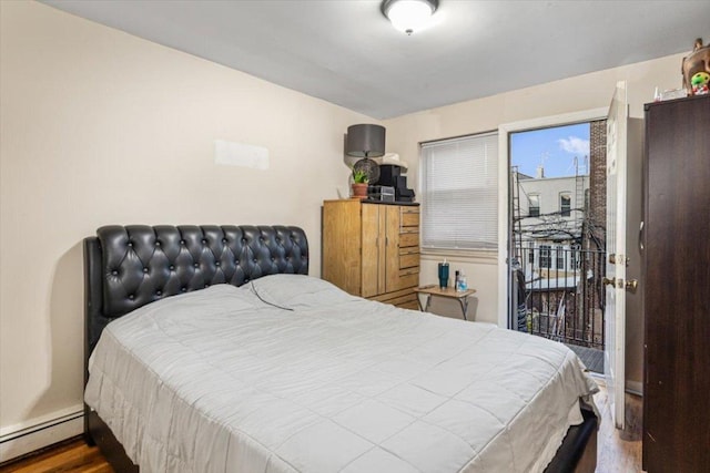 bedroom with wood-type flooring, access to exterior, and a baseboard heating unit