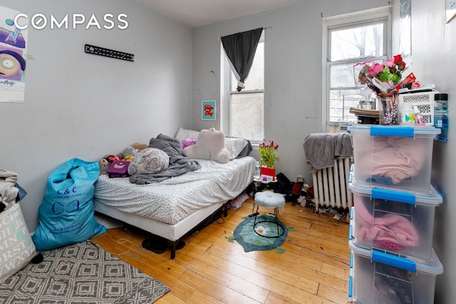 bedroom featuring wood-type flooring and radiator