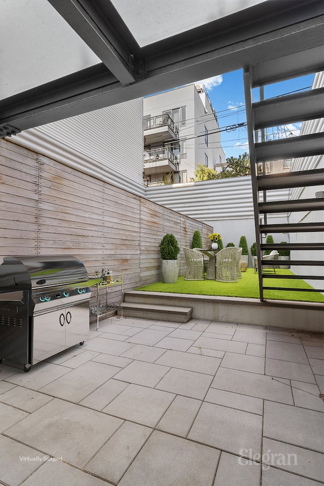 view of patio with a grill and stairs