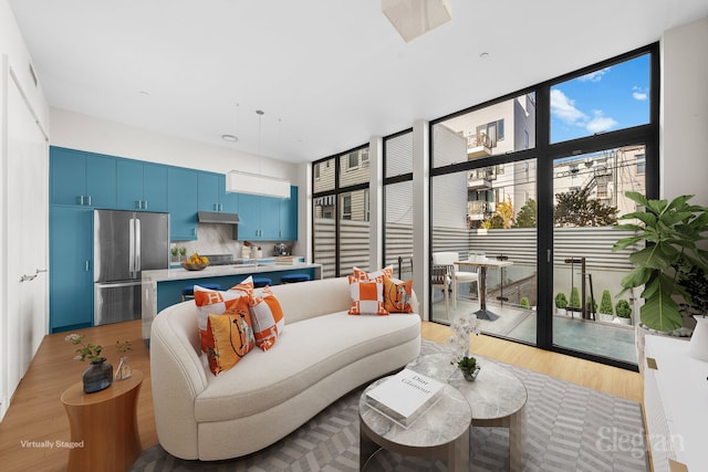 living area featuring light wood finished floors and a wall of windows