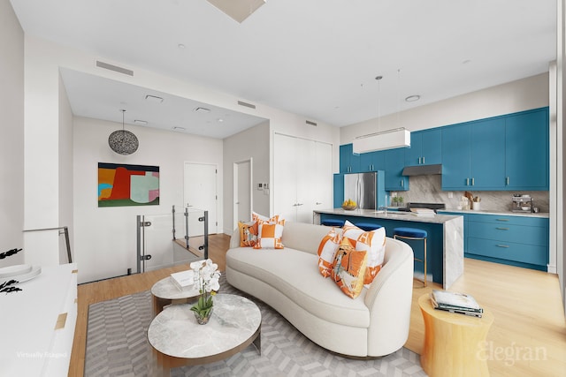 living room with visible vents and light wood-style floors