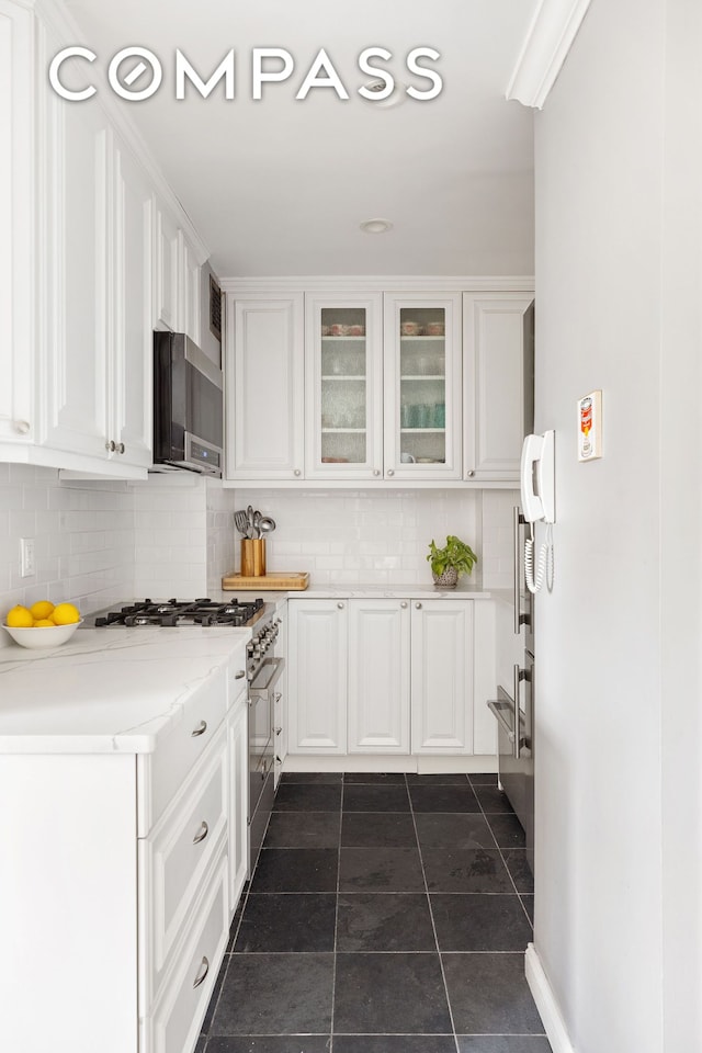 kitchen with tasteful backsplash, white cabinetry, and stainless steel appliances