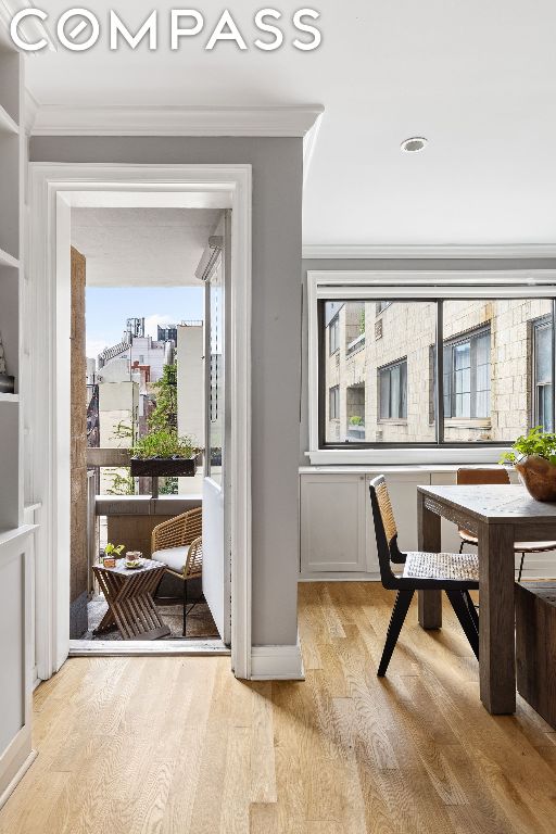 doorway featuring ornamental molding and light hardwood / wood-style floors