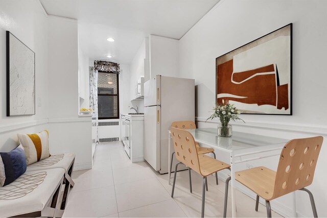 tiled dining room featuring sink and radiator heating unit