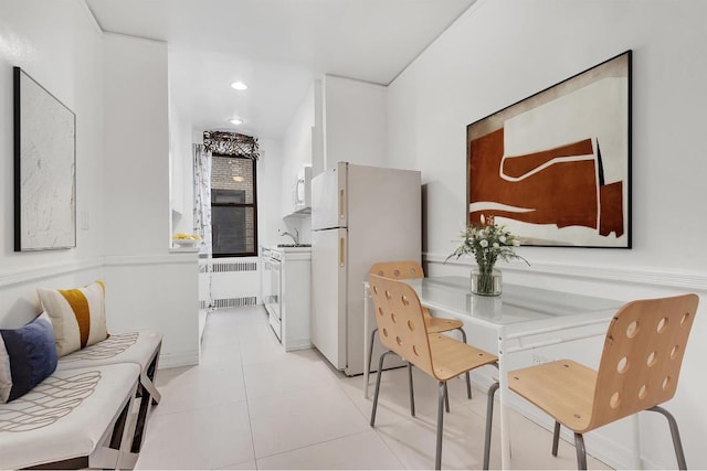 dining area featuring radiator, sink, and light tile patterned floors