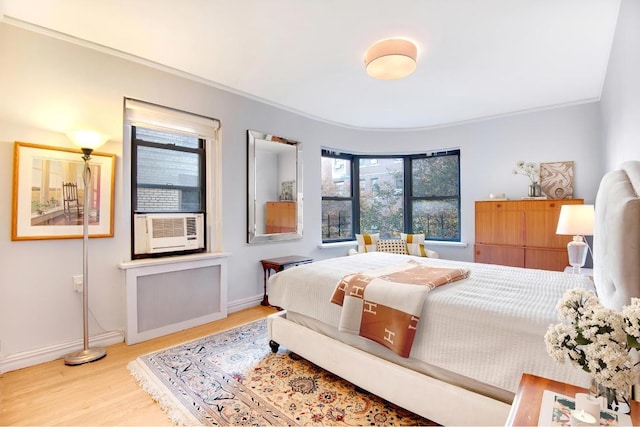 bedroom featuring crown molding and light hardwood / wood-style flooring