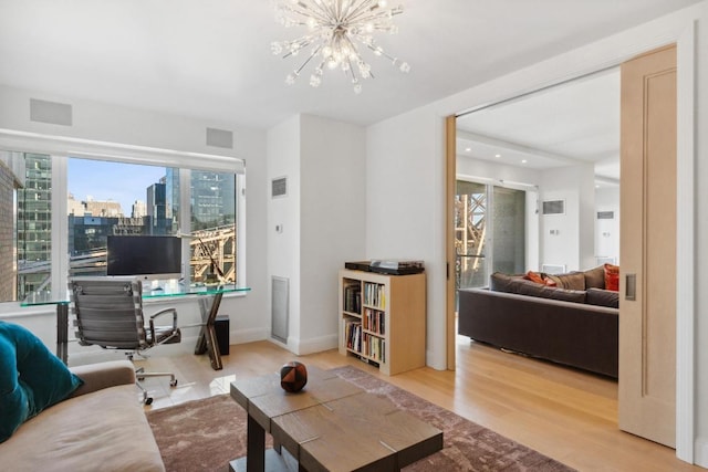 living room featuring an inviting chandelier and wood-type flooring