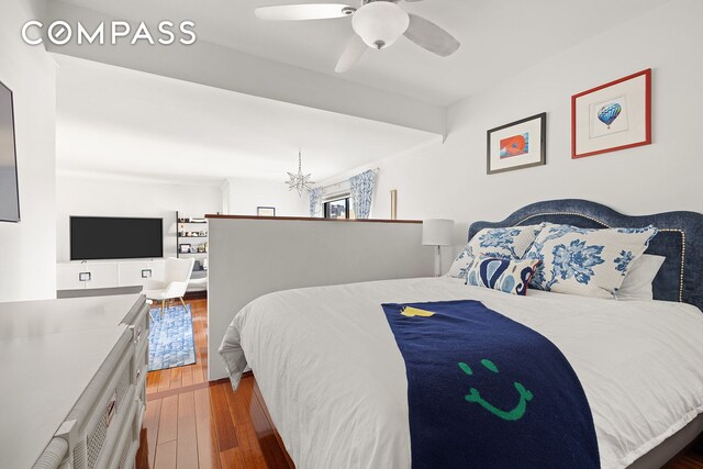 bedroom with dark hardwood / wood-style flooring and ceiling fan with notable chandelier