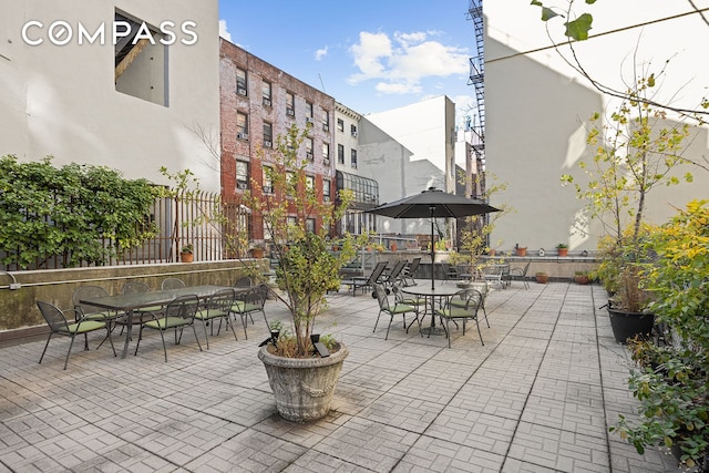 view of patio featuring outdoor dining area and fence