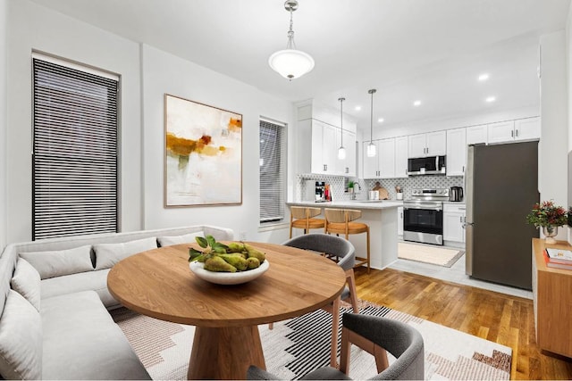 dining room featuring recessed lighting and light wood-style flooring