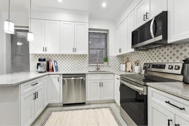100 W 88th St Unit 5C, New York City, NY 10024 - kitchen featuring appliances with stainless steel finishes, a sink, a peninsula, white cabinets, and light stone countertops