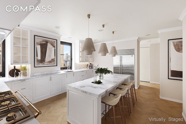 435 E 52nd St Unit 11A, New York City, NY 10022 - kitchen with stainless steel appliances, glass insert cabinets, crown molding, a kitchen breakfast bar, and baseboards