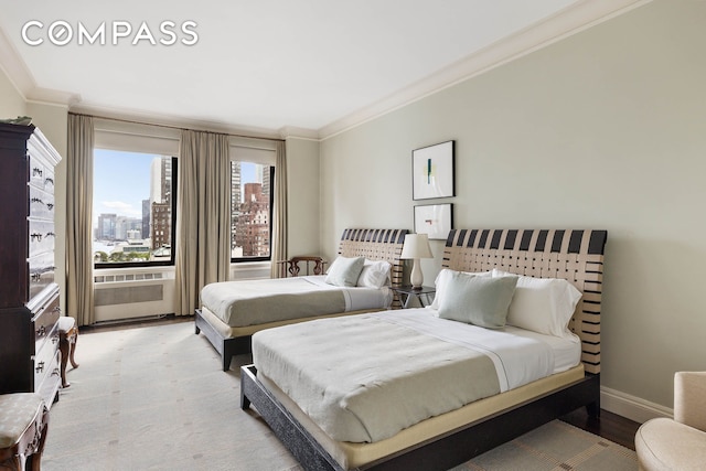 435 E 52nd St Unit 11A, New York City, NY 10022 - bedroom featuring crown molding, wood finished floors, baseboards, and a view of city