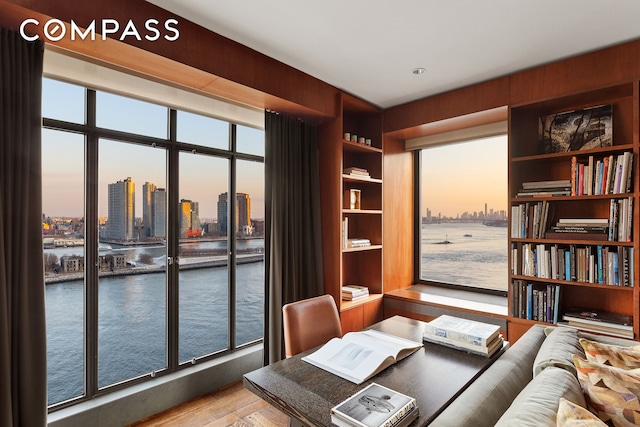 435 E 52nd St Unit 11A, New York City, NY 10022 - home office with a water view, wood finished floors, a skyline view, and built in shelves
