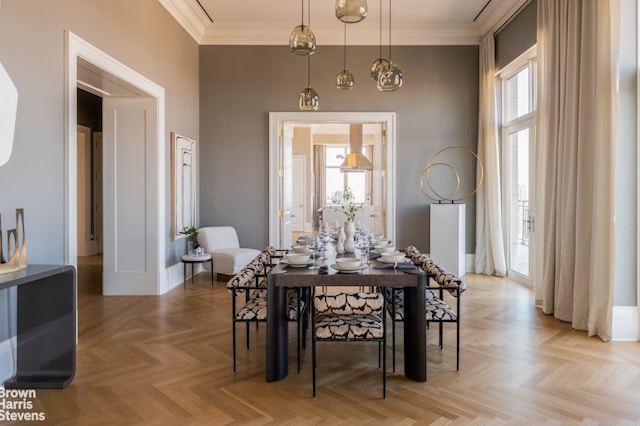 dining room featuring a wealth of natural light, baseboards, a high ceiling, and ornamental molding