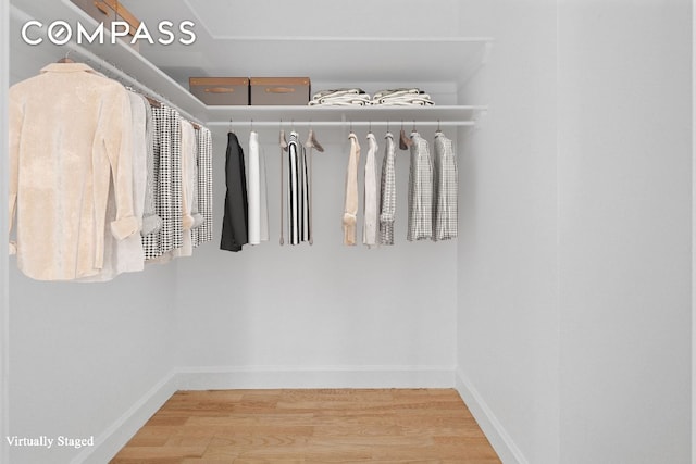 walk in closet with wood finished floors