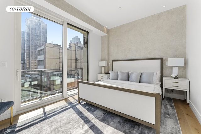 bedroom featuring access to outside and hardwood / wood-style flooring