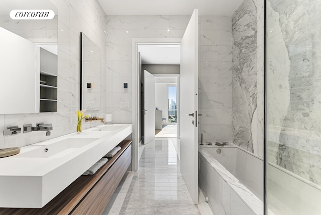 bathroom with tile walls, tiled tub, and vanity