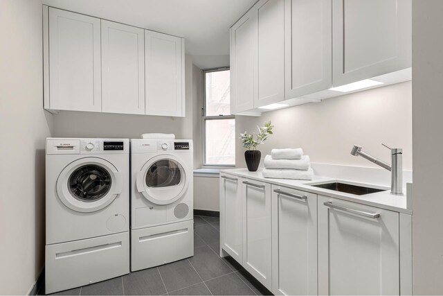 laundry area with cabinet space, washer and dryer, and dark tile patterned floors