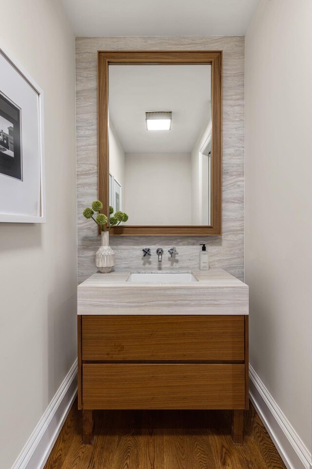 bathroom featuring vanity, wood finished floors, and baseboards