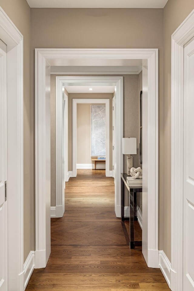 hallway featuring wood finished floors and baseboards