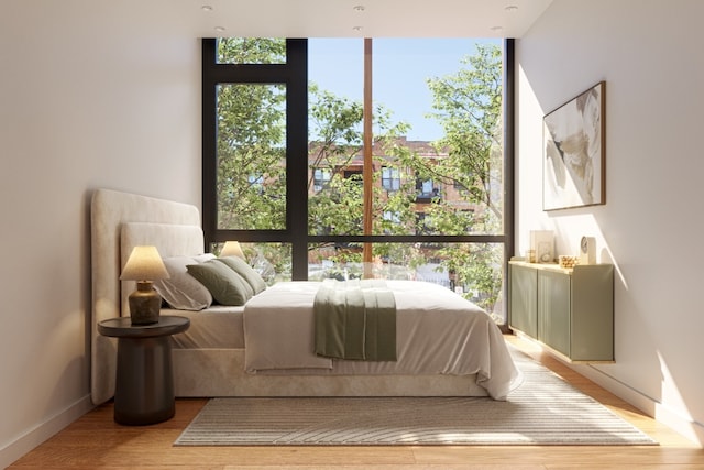 bedroom featuring floor to ceiling windows and light hardwood / wood-style flooring