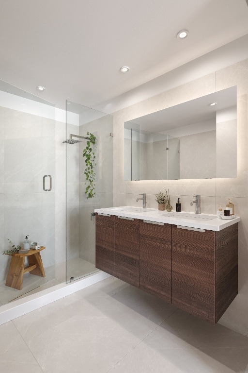 bathroom with a shower with shower door, tile patterned floors, and vanity