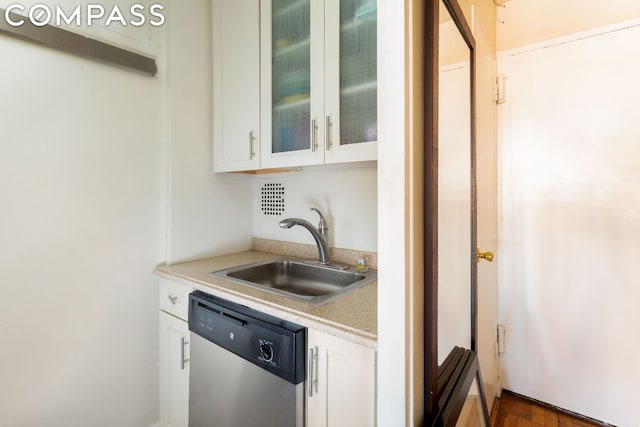 kitchen with white cabinetry, dishwasher, and sink