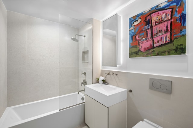 bathroom featuring tiled shower / bath and vanity