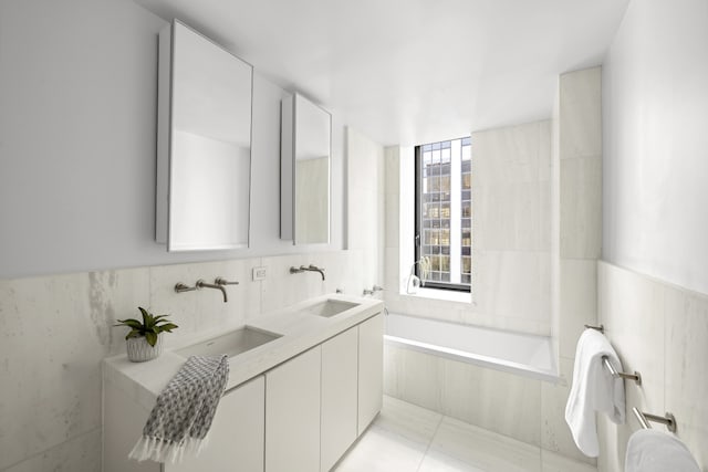 bathroom featuring a sink and tile walls