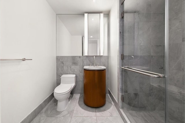 bathroom with tile patterned flooring, vanity, a shower with shower door, and toilet