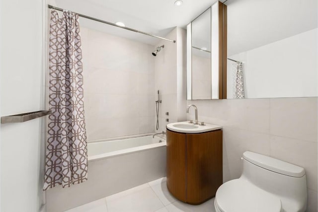 full bathroom with shower / tub combo with curtain, tile patterned floors, toilet, tile walls, and vanity