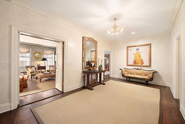 sitting room with ornamental molding, an inviting chandelier, and dark hardwood / wood-style flooring